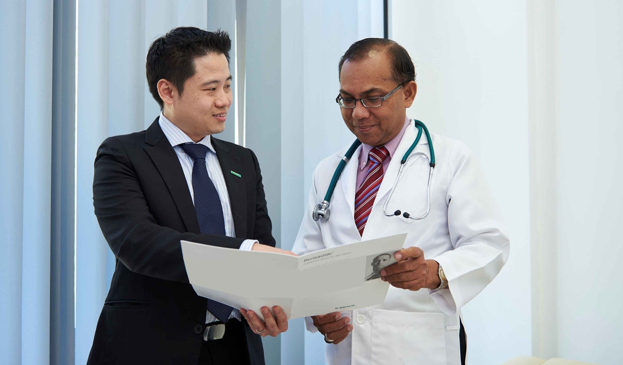 A professional and a doctor discussing medical information in a meeting room. 